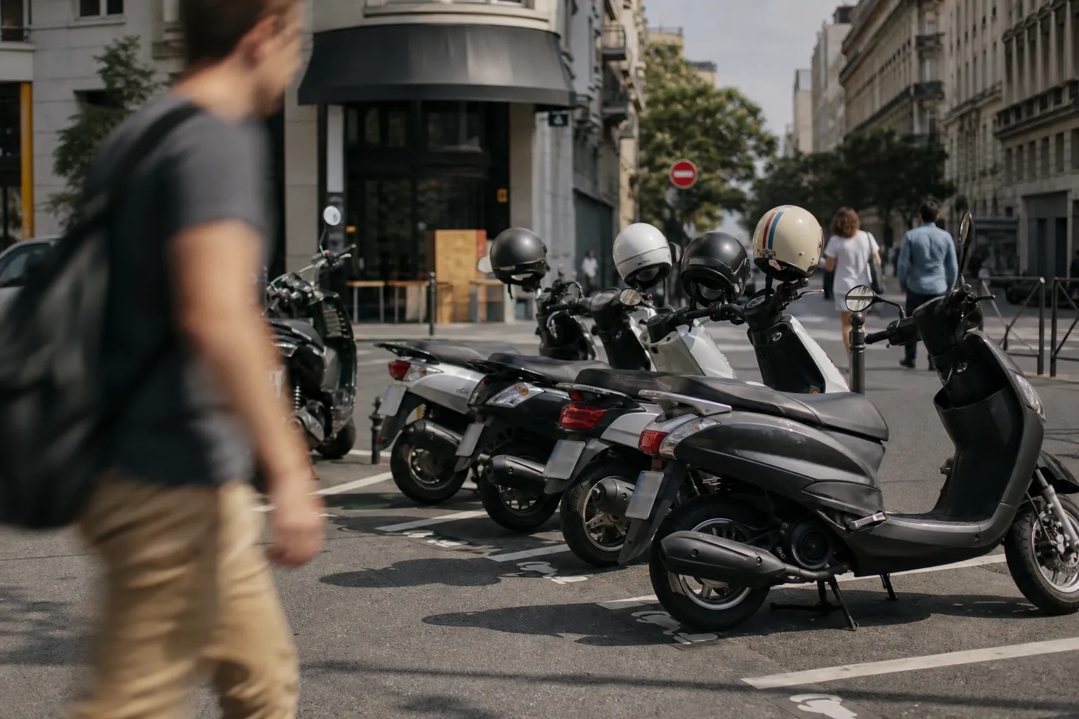Scooters 50 garés en épi sur un emplacement dédié aux deux-roues dans une rue française, matinée ensoleillée